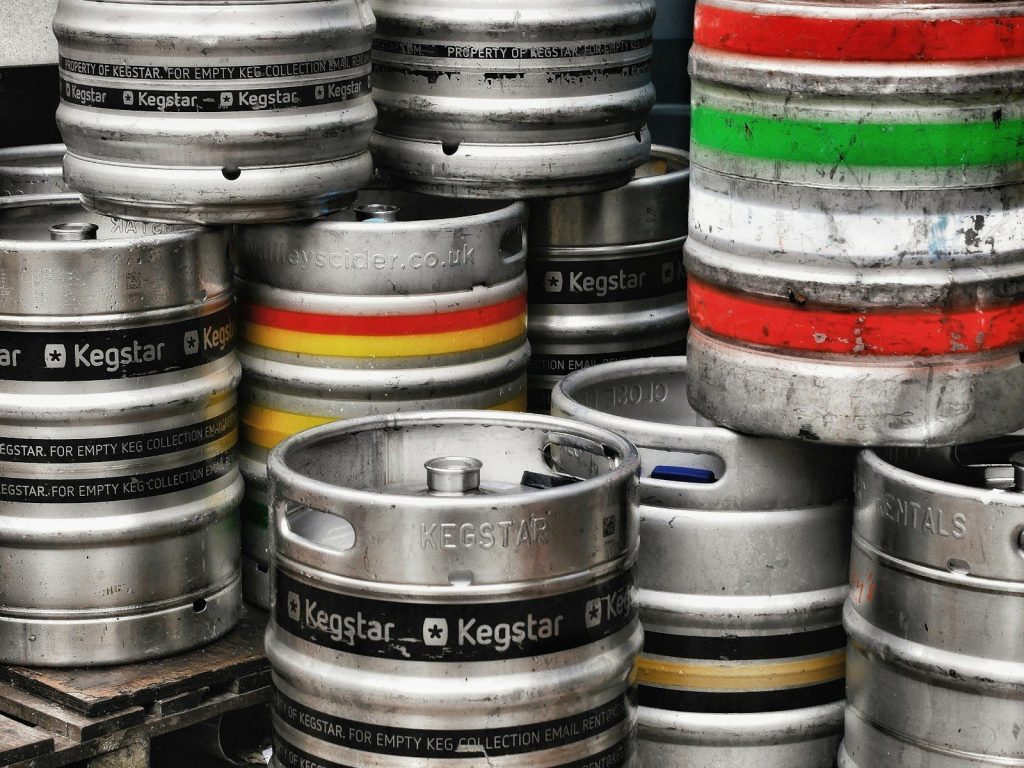 Stack of metal beer kegs with colored bands