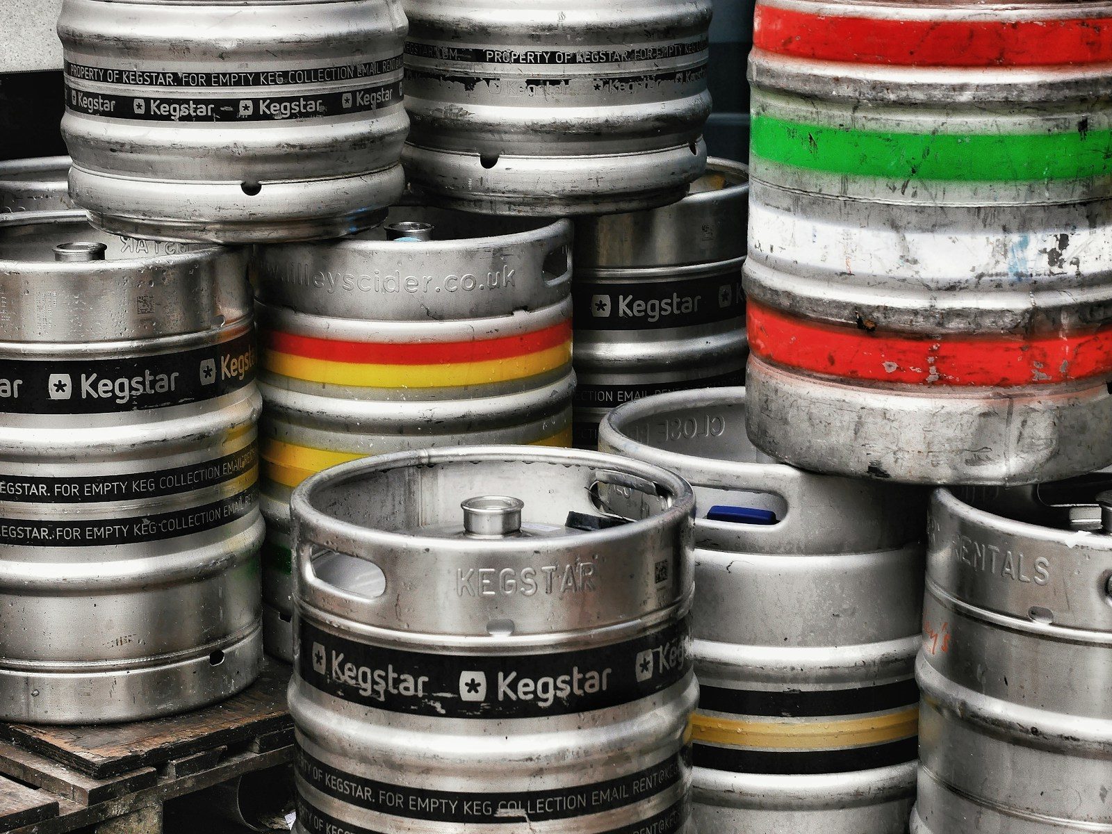 Stack of metal beer kegs with colored bands